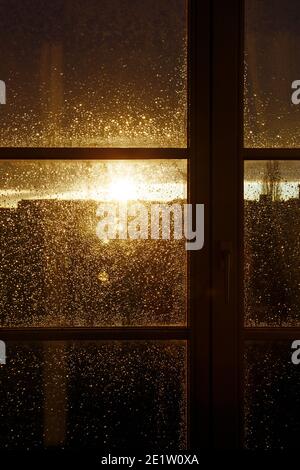 raindrops on a window pane at sunset Stock Photo