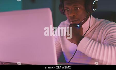 Black creative man, with illuminated headset working late at night. High quality photo Stock Photo