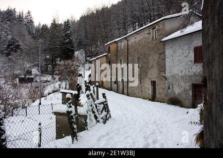 abandoned village in white snowy mountain peak in reverse in the forest in tuscany Stock Photo
