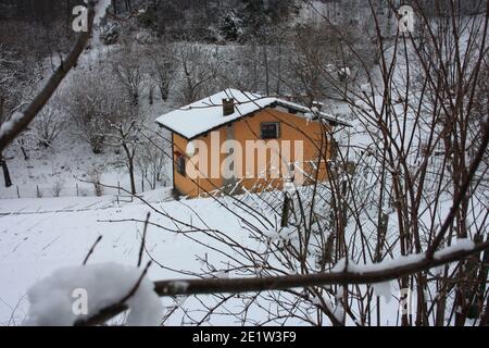 lonely modern cabin in the mountain peak among the white winter snow in tuscany Stock Photo