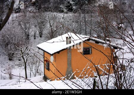 lonely modern cabin in the mountain peak among the white winter snow in tuscany Stock Photo