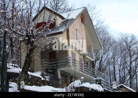 lonely modern cabin in the mountain peak among the white winter snow in tuscany Stock Photo