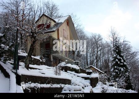 lonely modern cabin in the mountain peak among the white winter snow in tuscany Stock Photo