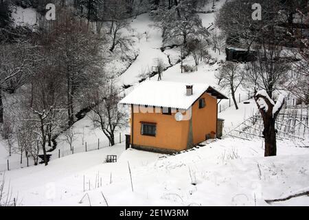 lonely modern cabin in the mountain peak among the white winter snow in tuscany Stock Photo