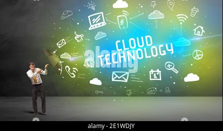 Businessman defending with umbrella from CLOUD TECHNOLOGY inscription, modern technology concept Stock Photo