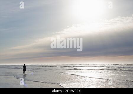 Silhouette of a man alone on a beach. Stock Photo