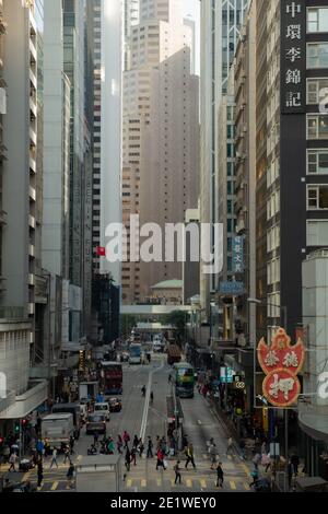 Des Voeux Road in Hong Kong comes alive with the vibrant energy of urban life, framed by the iconic Standard Chartered Bank Building and bustling crow Stock Photo