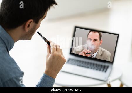 Virtual Smoking Break Using Electronic Cigarettes And Video Conference Stock Photo