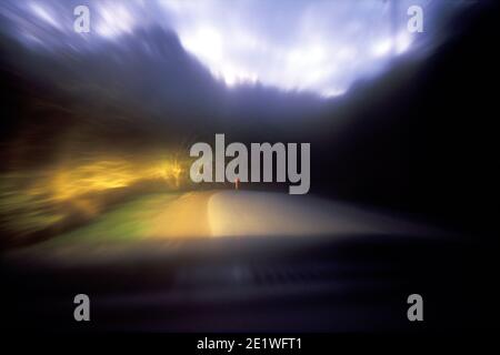 A VEHICLE APPROACHES A SHARP BEND ON AN UNLIT COUNTRY ROAD AT NIGHT IN SOUTH AUSTRALIA. Stock Photo