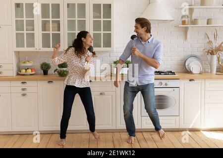 Happy couple have fun dancing together in kitchen Stock Photo