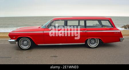 Classic Red Chevrolet Impala Station Wagon parked on seafront promenade. Stock Photo