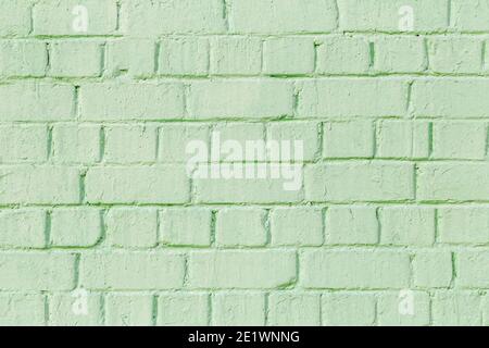 Background with brick, uneven texture wall. Brickwork is painted green color. Stock Photo