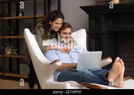 Happy millennial couple relax using laptop together Stock Photo