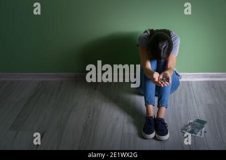 Female junkie sitting near color wall Stock Photo - Alamy