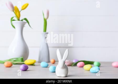 Easter eggs, figure of bunny and flowers on table Stock Photo
