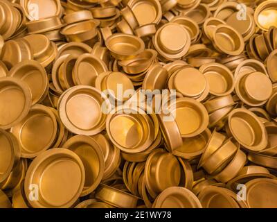 pile of stamped thin sheet brass hat-shaped semimanufatures, closeup with selective focus and blur Stock Photo