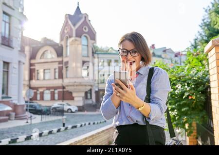 Smiling female making video call, looking at smartphone screen and talking Stock Photo