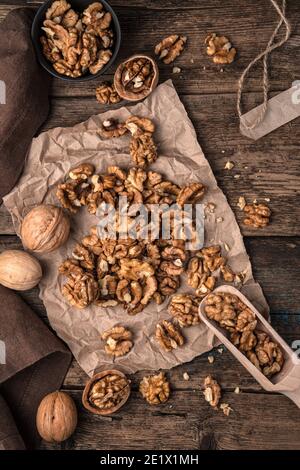 Walnuts in shell and peeled on a wooden background. Top view, vertical orientation. Stock Photo