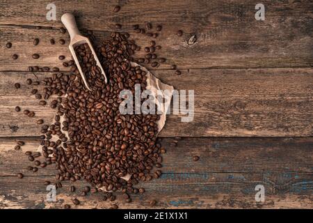 Coffee background with coffee beans and wooden spatula on wooden background. Stock Photo