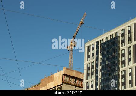 Construction crane on the background of the building. Construction of a new apartment building. Stock Photo