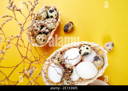 Easter eggs are minimalistically, decorated with dry flowers on yellow background. Top view, Copy space, Creative flat lay holiday composition. Stock Photo