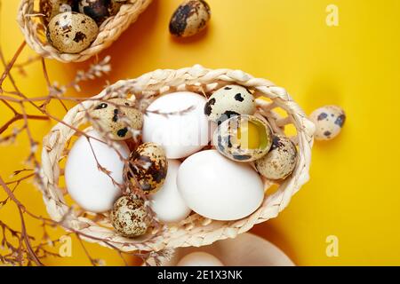 Easter eggs are minimalistically, decorated with dry flowers on yellow background. Top view, Copy space, Creative flat lay holiday composition. Stock Photo