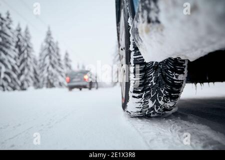 Close-up view of tire of car on snow covered and icy road. Themes safety and driving in winter. Stock Photo