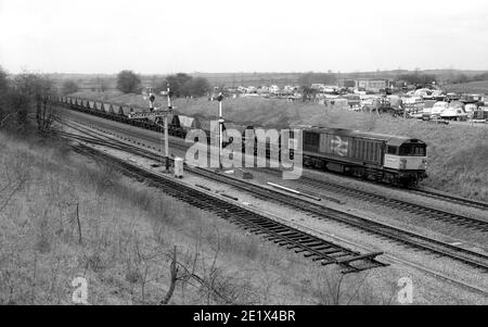 Class 58 diesel locomotive No.58033 heads an MGR coal train to Didcot Power Station at Fenny Compton, Warwickshire, UK. 1987 Stock Photo