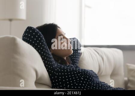 Relaxed young asian korean woman daydreaming on sofa. Stock Photo