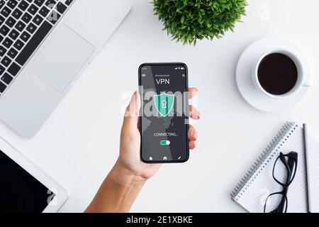 Young woman holding and using smartphone with vpn app Stock Photo