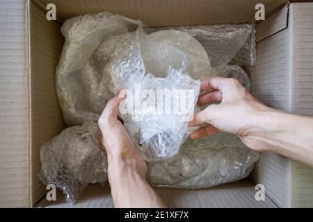 Wrapping a ceramic cup with bubble wrap Stock Photo