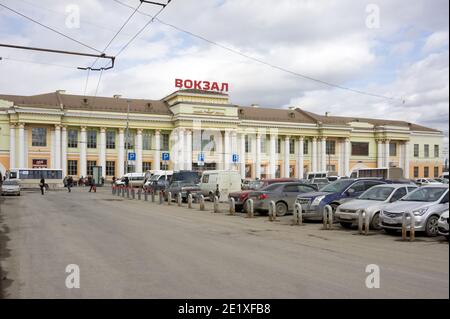 The main railway station (1914) of the city from the side of the Railway Station Square with parked cars on a cloudy spring day. Stock Photo