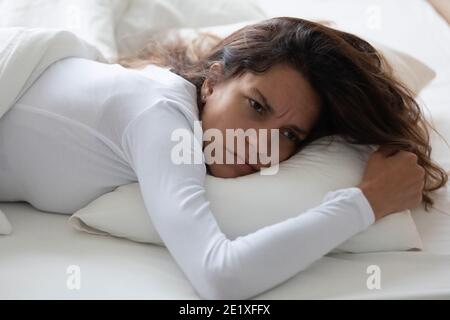 Close up unhappy woman lying in bed, suffering from insomnia Stock Photo