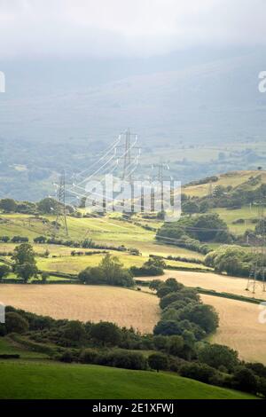 Electricity Pylons in the landscape of the Conwy Valley near the village of Eglwysbach Conwy Snowdonia Wales Stock Photo