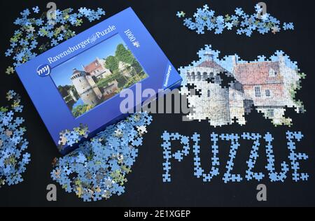 Jigsaw of British moated castle reflecting in water A puzzle challenge being completed and written down in blue pieces Hobby adored by adults children Stock Photo