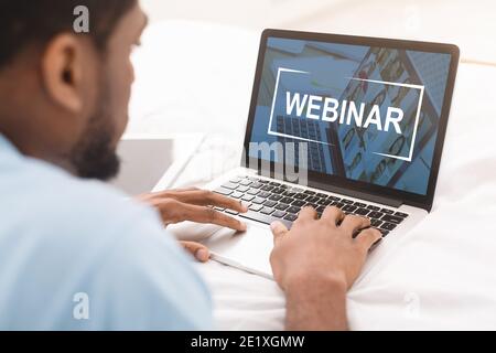 Black man having webinar on laptop while working in office Stock Photo