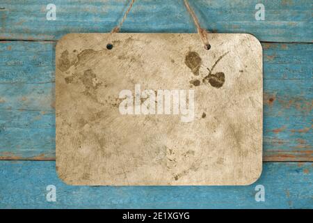blank grungy metal sign hanging on blue wooden planks wall, free copy space Stock Photo