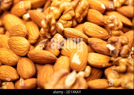 Almonds and walnuts scattered on the table. Close-up, selective focus Stock Photo