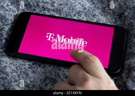 T-Mobile is a mobile communications company. TMobile App on iPhone 11 with Vodafone logo. #T-Mobile Stock Photo