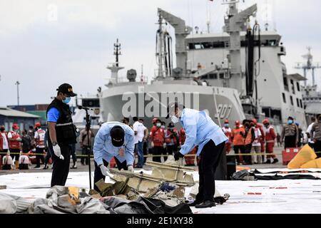 North Jakarta, Indonesia. 10th Jan, 2021. Indonesian Search and Rescue (SAR) team and Disaster Victim Identification (DVI) police officers looking through a bag of suspected debris during the search at Tanjung Priok Port. Sriwijaya Air flight SJ182 with 62 people on board from Jakarta to Pontianak, Indonesia, lost contact with air controllers shortly after take-off and crashed into the waters off the coast of Jakarta. Indonesian authorities say they have found the location where they believe the plane crashed into the sea. Credit: SOPA Images Limited/Alamy Live News Stock Photo