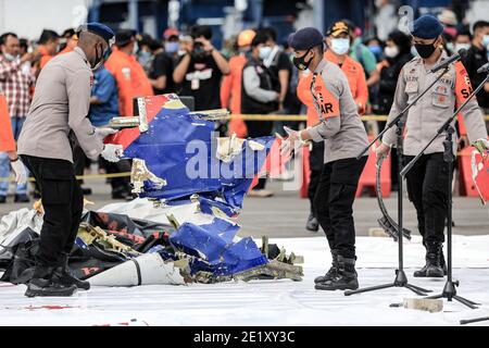 North Jakarta, Indonesia. 10th Jan, 2021. Indonesian Search and Rescue (SAR) team and Disaster Victim Identification (DVI) police officers with a bag of the suspected debris during the search at Tanjung Priok Port. Sriwijaya Air flight SJ182 with 62 people on board from Jakarta to Pontianak, Indonesia, lost contact with air controllers shortly after take-off and crashed into the waters off the coast of Jakarta. Indonesian authorities say they have found the location where they believe the plane crashed into the sea. Credit: SOPA Images Limited/Alamy Live News Stock Photo