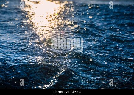 Waves at surface of ocean. Water texture with bokeh and drops Stock Photo