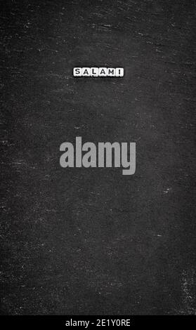 Word salami on black stone background Stock Photo