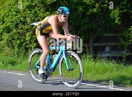 Close up of Female triathlete on road cycling stage. Stock Photo
