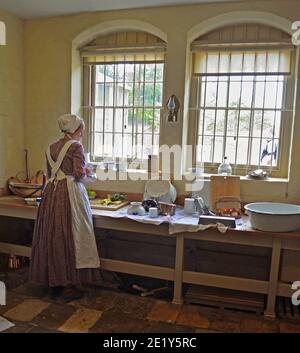 Victorian Kitchen maid preparing food by window.. Stock Photo