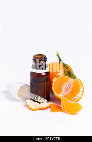 isolate, glass vial with pipette and tangerine on white background Stock Photo