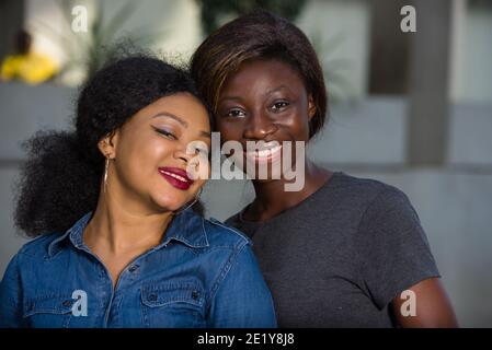 portrait of two women smiling and happy laughing and standing together outdoors Stock Photo