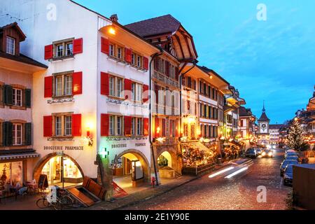 Night scene with Christmas decorations in the old town of Murten (Morat in French) in Fribourg Canton of Switzerland, along the Hauptgasse street with Stock Photo