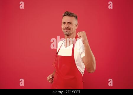 yes, we did it. cheerful mature waiter celebrate success. waiter in a restaurant. he will take the order. best waiter service. handsome waiter in red apron. Successful small business owner. Stock Photo