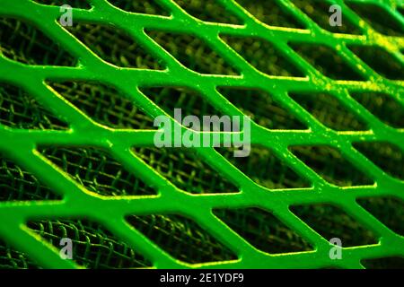 Green metal lattice lozenge rhombus close-up, under a fine metal grid Stock Photo